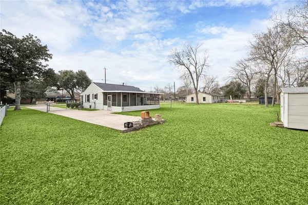 a view of a house with a big yard and large trees
