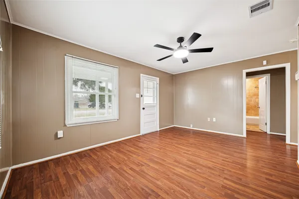 a view of an empty room with a window and a ceiling fan