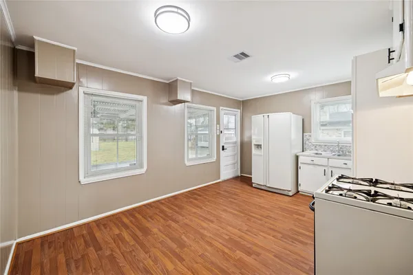 a view of a kitchen with stainless steel appliances granite countertop a refrigerator and a stove top oven
