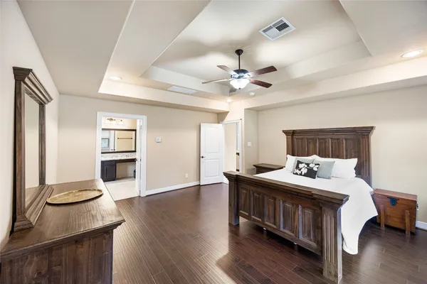 a spacious bedroom with a bed and a chandelier
