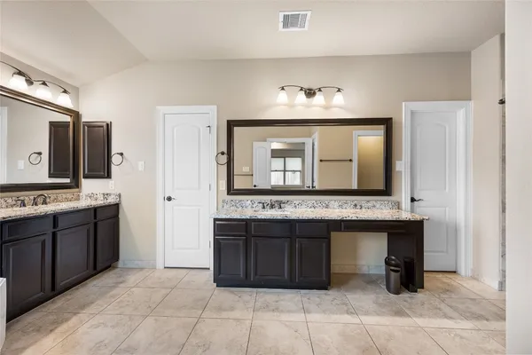 a bedroom with a large bed and a potted plant