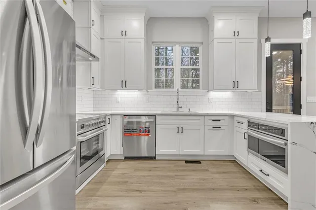 a kitchen with stainless steel appliances granite countertop a stove a sink and a refrigerator