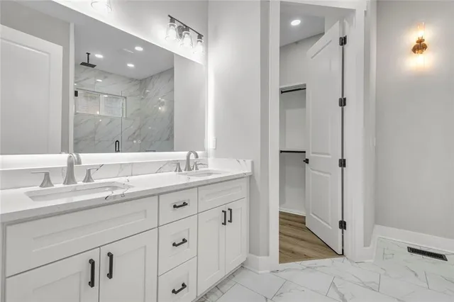 a bathroom with a granite countertop sink mirror and shower