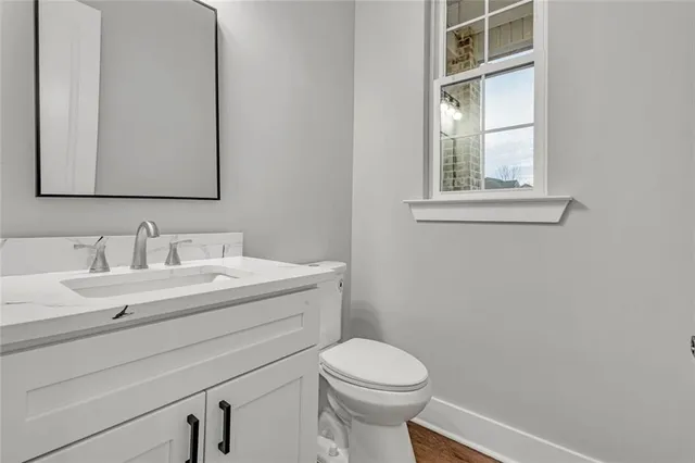 a bathroom with a sink vanity mirror and toilet