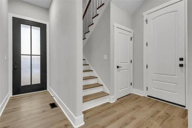 a view of a hallway with wooden floor and entryway