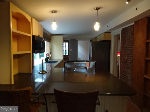 a kitchen with sink refrigerator dining table and chairs