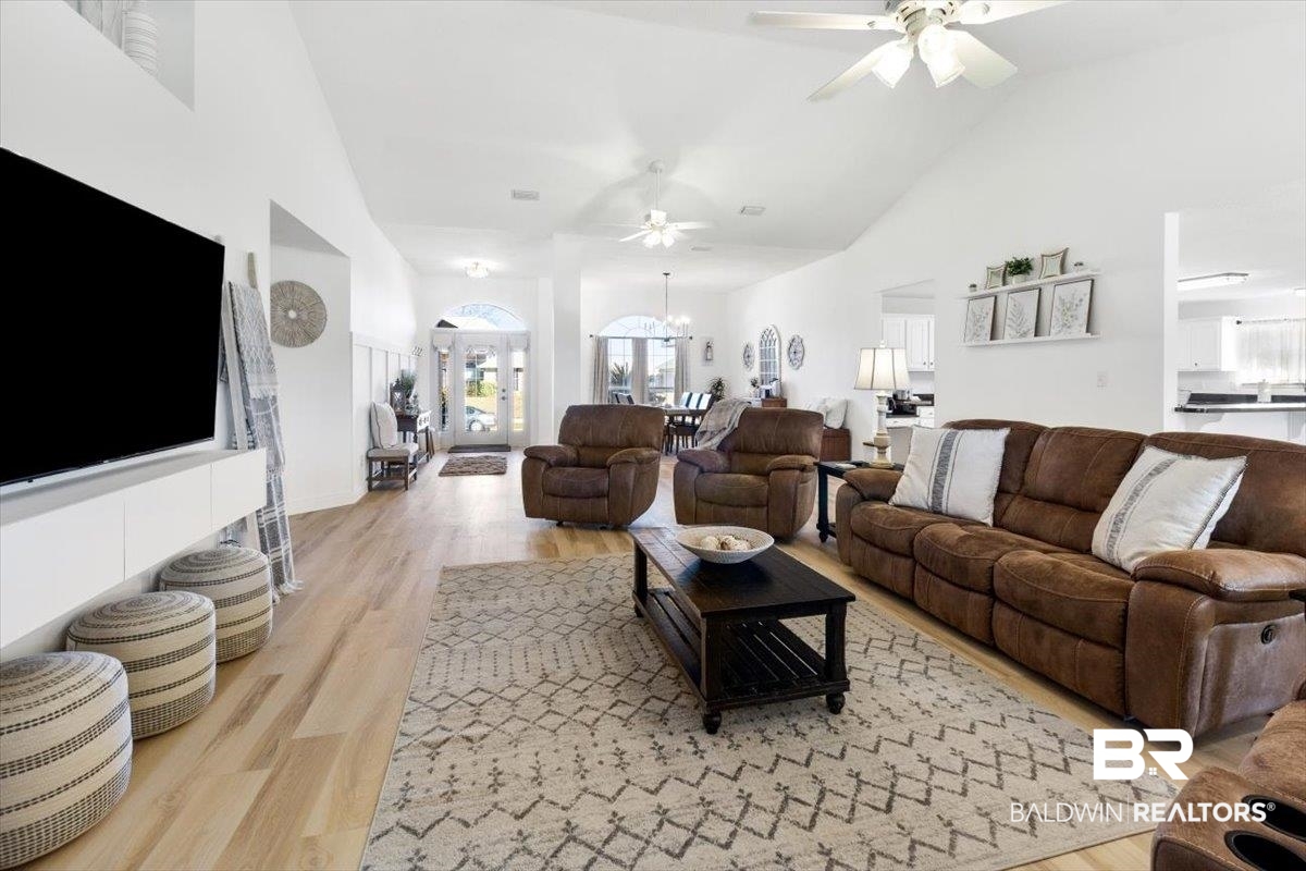 27809 Rileywood Drive Daphne, AL 36526 - Photo 9 of 38 Living room with ceiling fan with notable chandelier, high vaulted ceiling, and light hardwood / wood-style flooring