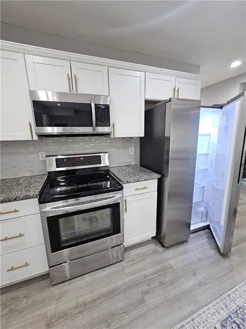 a large kitchen with a stove a sink and a refrigerator