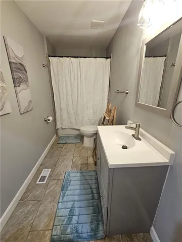 a bedroom with a bed and painting on the wall