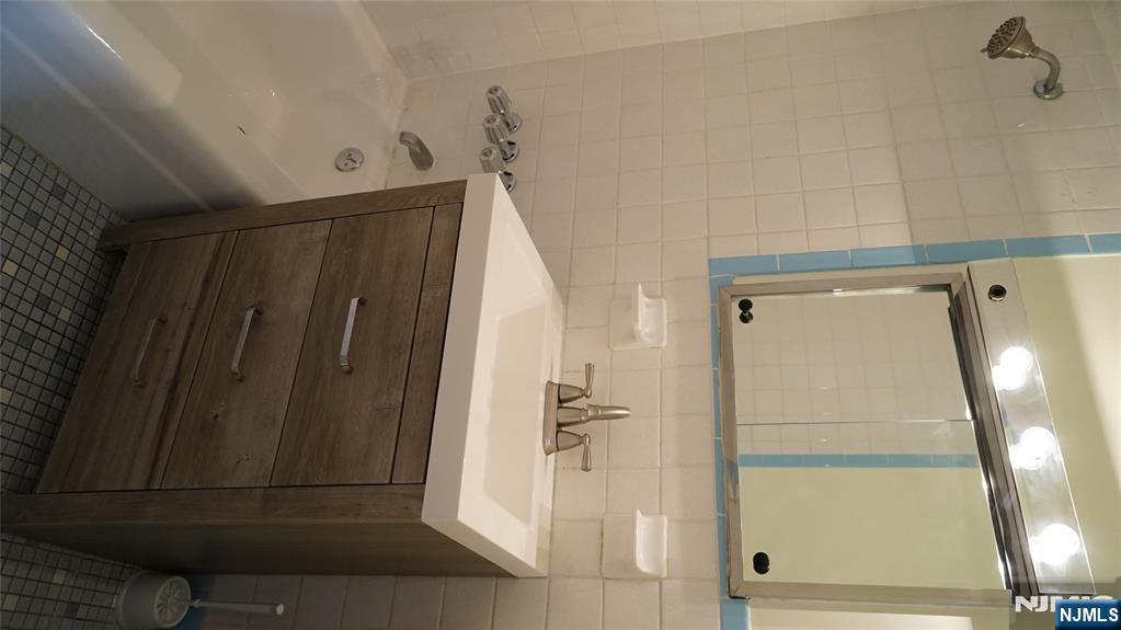 403 Anderson Avenue, Unit 4B Fairview, NJ 07022 - Photo 7 of 12 a bathroom with a sink and a bathtub