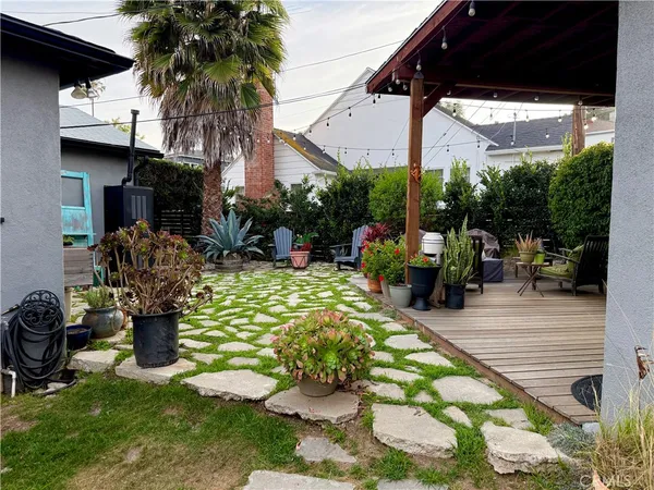a view of a chairs and table in backyard of a house