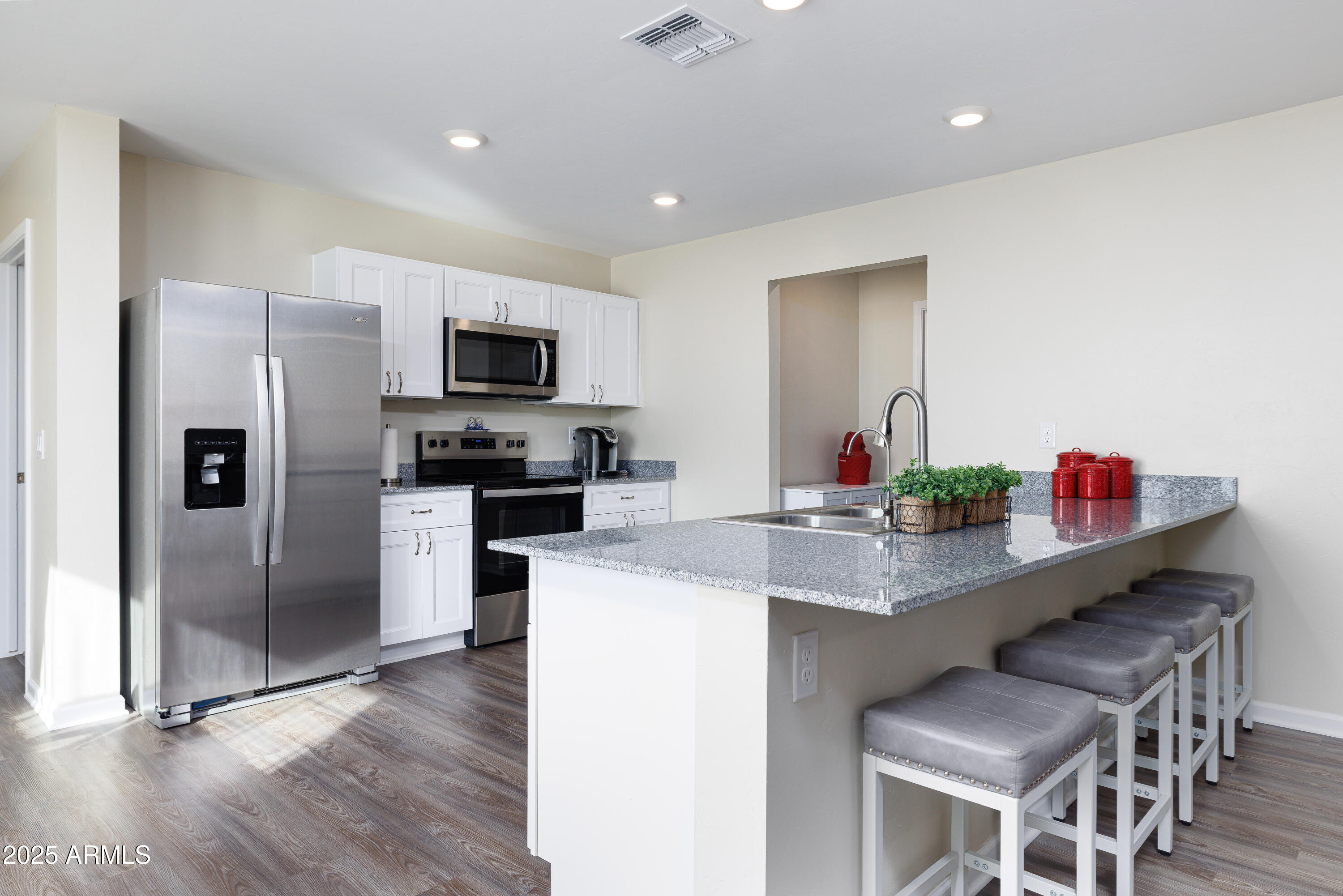 1256 South Lenora Loop Benson, AZ 85602 - Photo 11 of 34 a kitchen with stainless steel appliances kitchen island granite countertop a refrigerator and a stove top oven