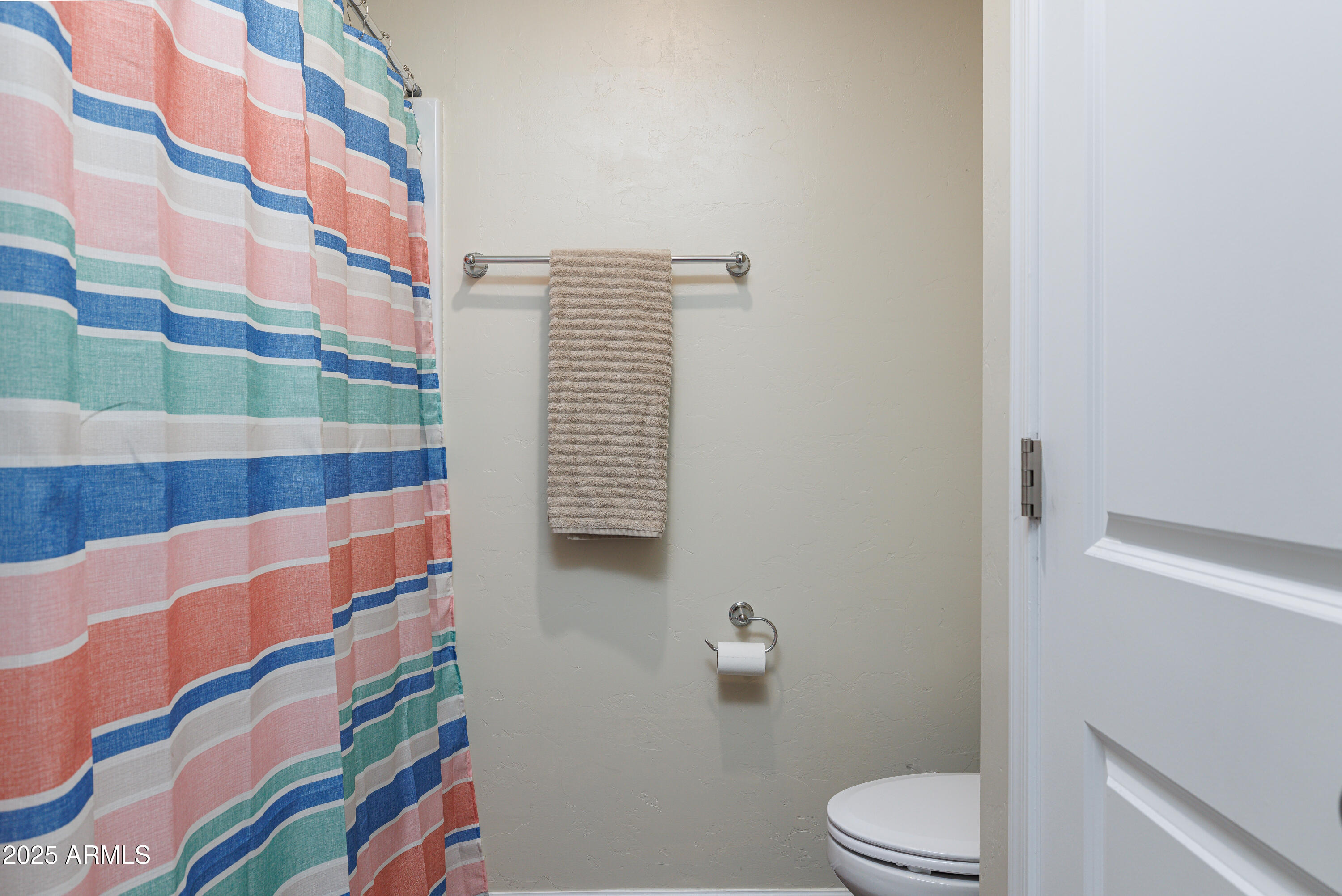 1256 South Lenora Loop Benson, AZ 85602 - Photo 21 of 34 a white toilet sitting next to a shower curtain