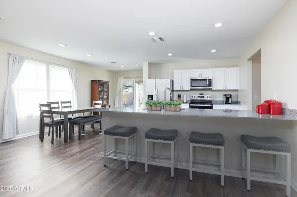 a kitchen with a sink dishwasher and a stove with wooden floor