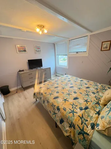 a bedroom with a bed and a dresser with mirror