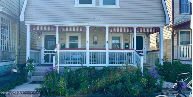 a view of a house with potted plants and a table and chairs