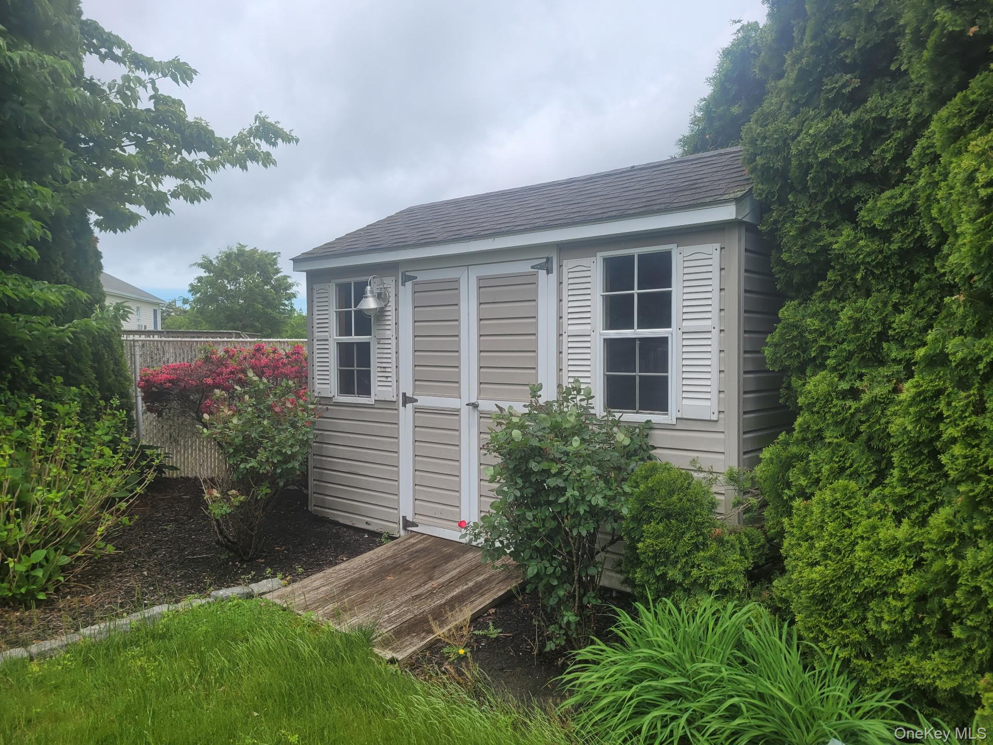 312 Riley Avenue Calverton, NY 11933 - Photo 25 of 30 Detached storage shed with horizontal siding, louvered shutters, and a shingled roof