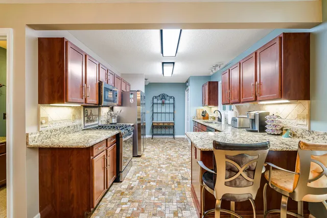 a kitchen with granite countertop lots of counter top space and stainless steel appliances