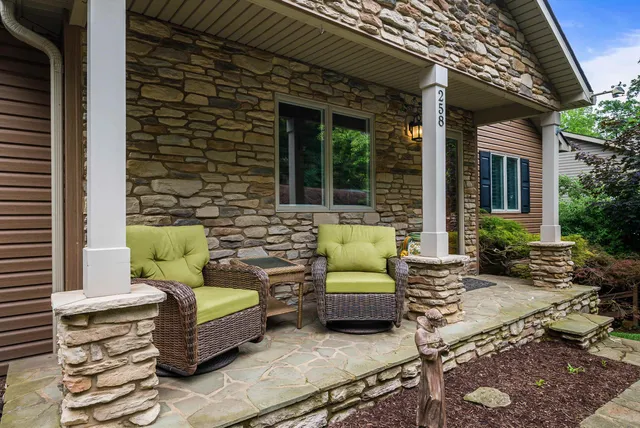 a patio with wooden floor a yard a table and chairs