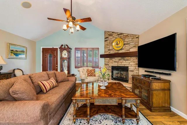 a living room with furniture a flat screen tv and a large window