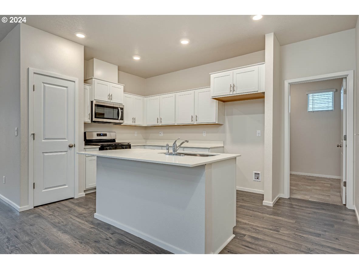 2708 V Street Springfield, OR 97477 - Photo 9 of 26 a kitchen with kitchen island a sink stainless steel appliances and cabinets