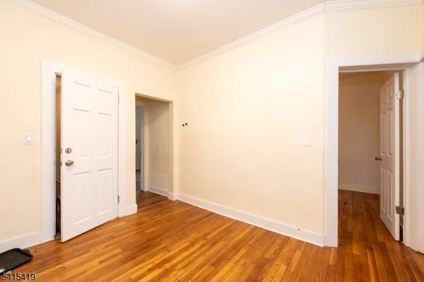 a view of a room with wooden floor and a bathroom