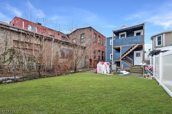 a view of a house with a yard and potted plants