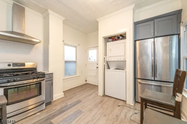 a kitchen with a refrigerator stove and wooden floor