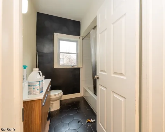 a view of bathroom with mirror toilet and window