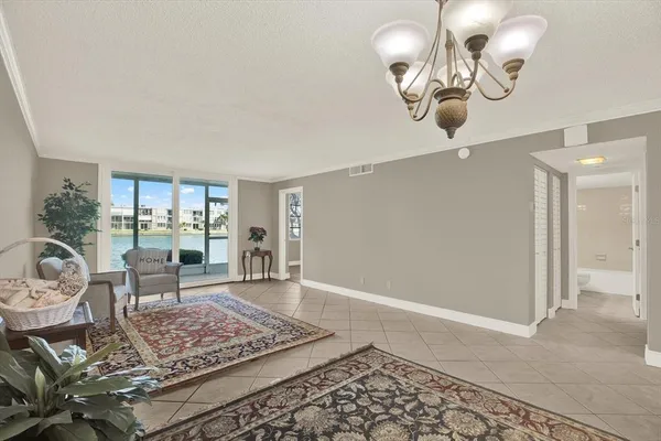 a living room with dining area and a chandelier