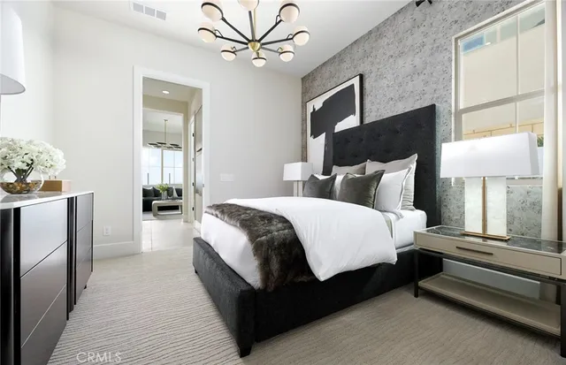 a bedroom with a bed and a chandelier