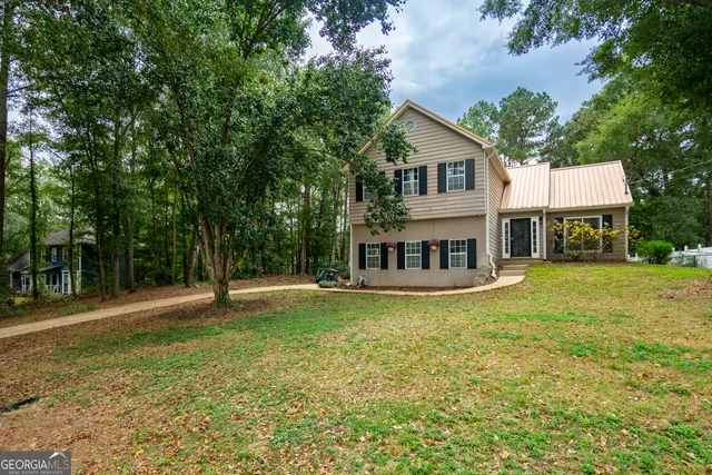 a view of a house with a yard deck and sitting area