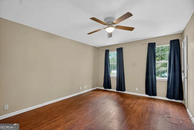 a view of a big room with wooden floor and windows