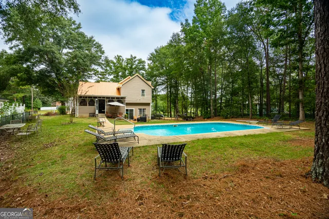 a swimming pool with outdoor seating and yard