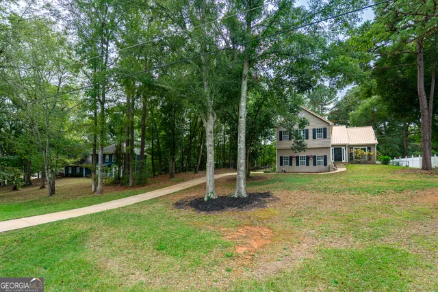 a view of a house with a backyard and a tree