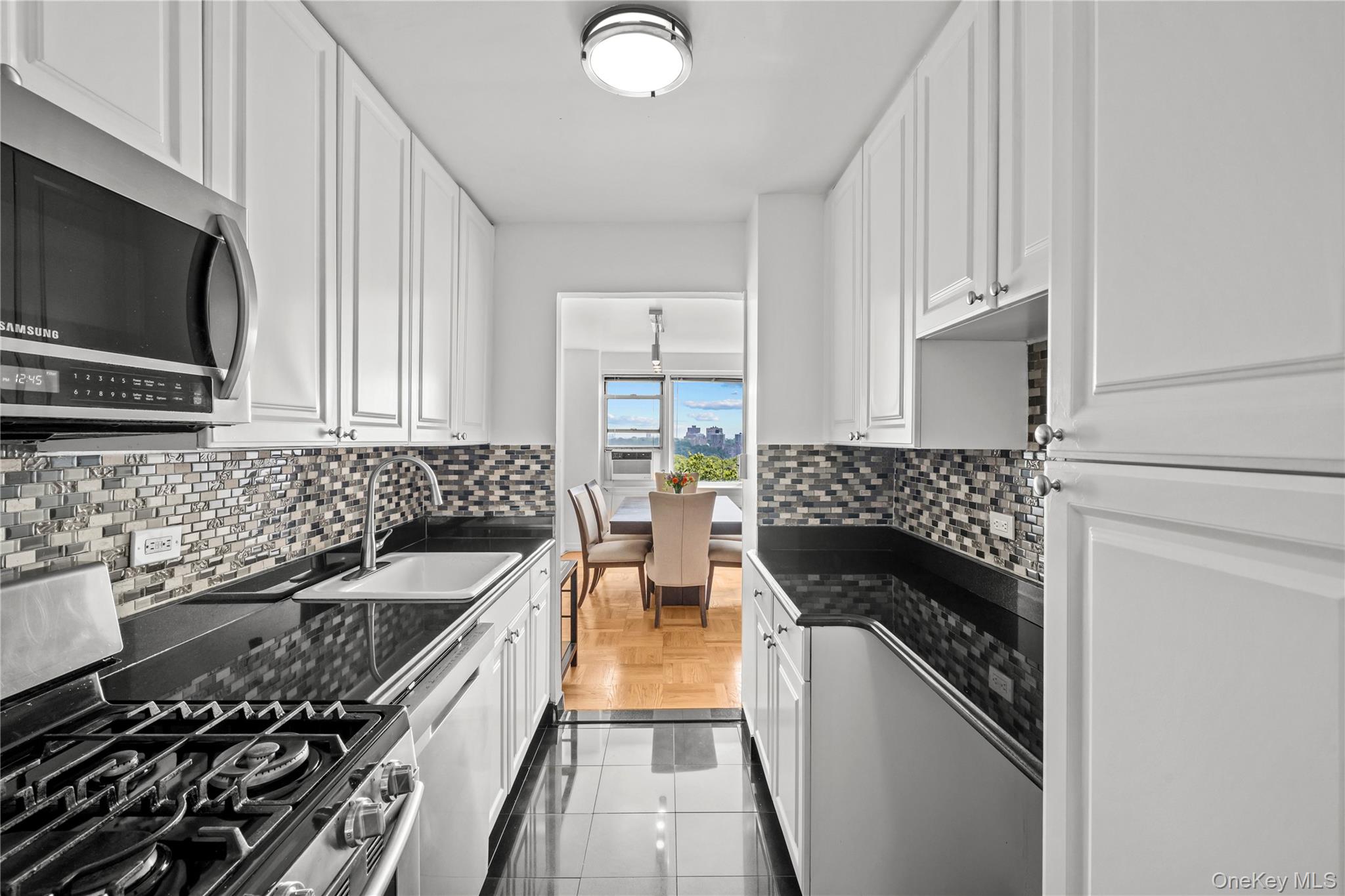 4555 Henry Hudson Parkway West, Unit A908 Bronx, NY 10471 - Photo 3 of 12 a kitchen with a stove and a microwave