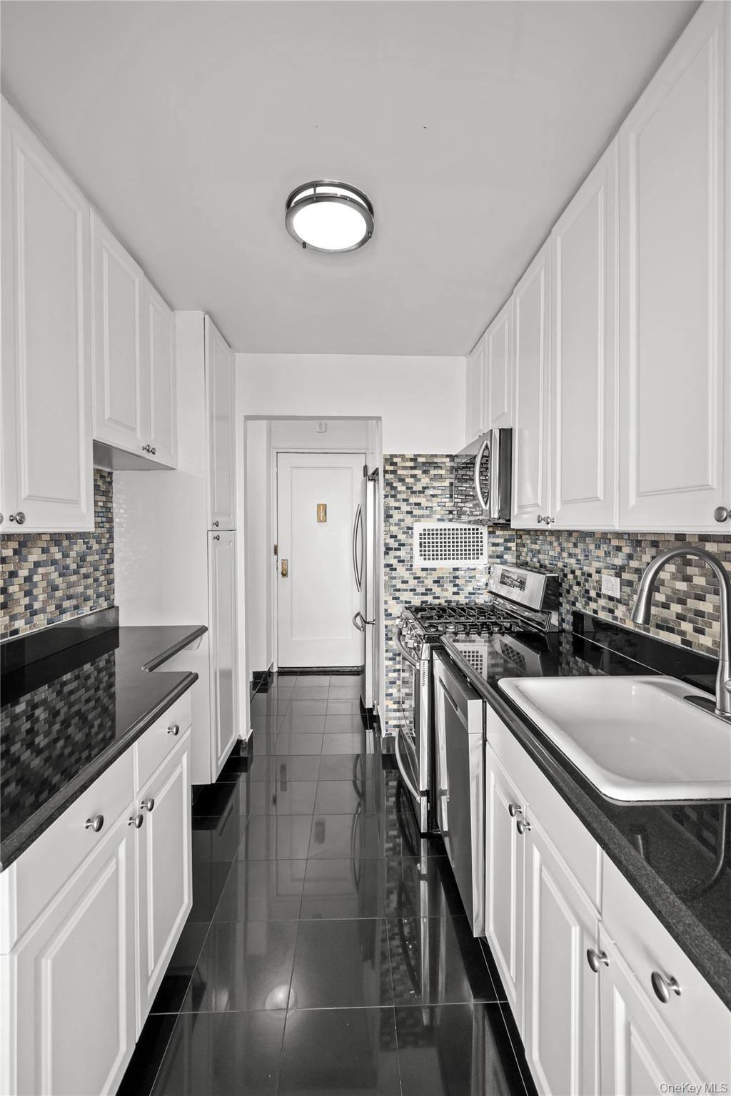 4555 Henry Hudson Parkway West, Unit A908 Bronx, NY 10471 - Photo 4 of 12 a kitchen with stainless steel appliances granite countertop a sink stove and cabinets