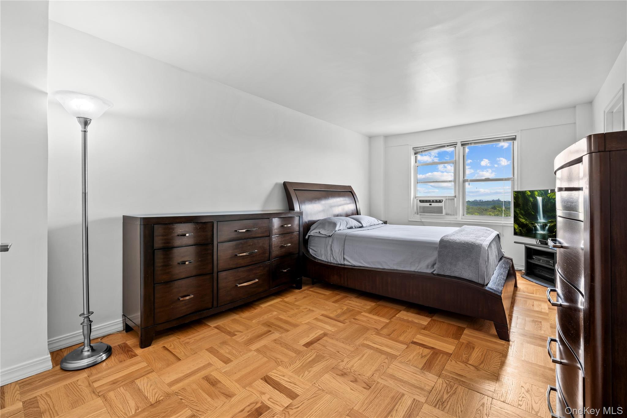 4555 Henry Hudson Parkway West, Unit A908 Bronx, NY 10471 - Photo 7 of 12 a bedroom with a bed and a night stand