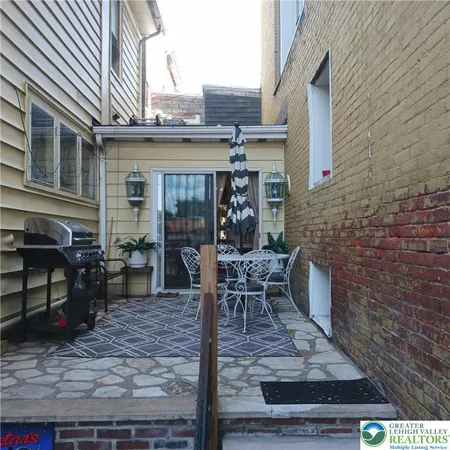 a view of a patio with table and chairs and wooden floor