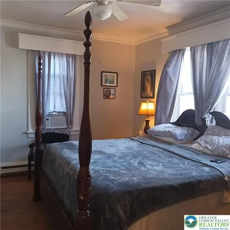 a bedroom with a bed and wooden floor