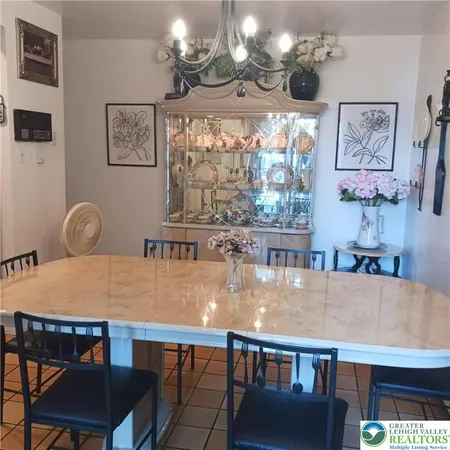 a dining room with wooden floor a chandelier a wooden table and chairs