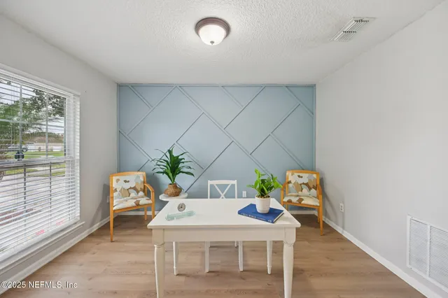 a dining room with furniture and a potted plant