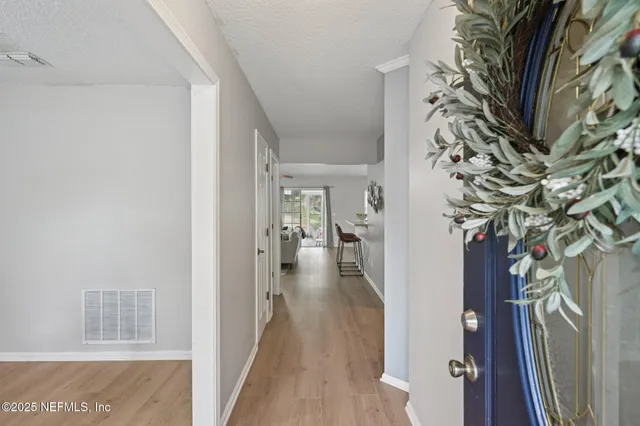 a view of a hallway with wooden floor and a living room