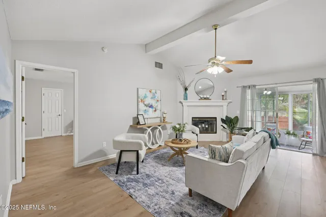 a living room with furniture a fireplace and a chandelier