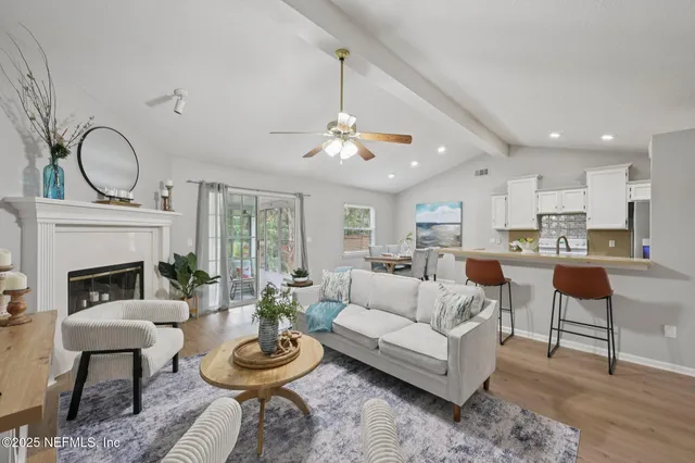 a living room with furniture a fireplace and a chandelier