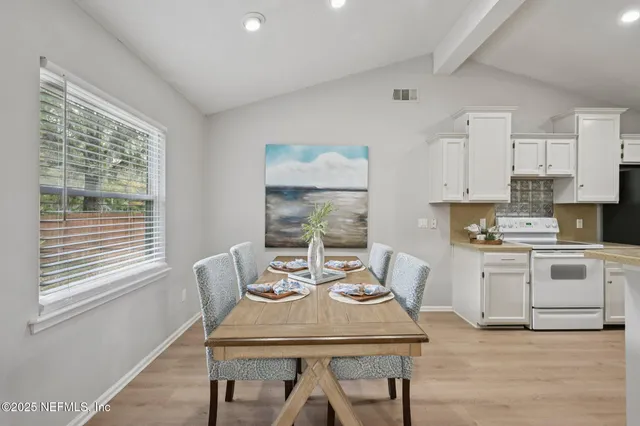 a kitchen with a table chairs and white appliances