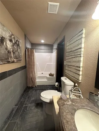 a bathroom with a granite countertop sink toilet and shower