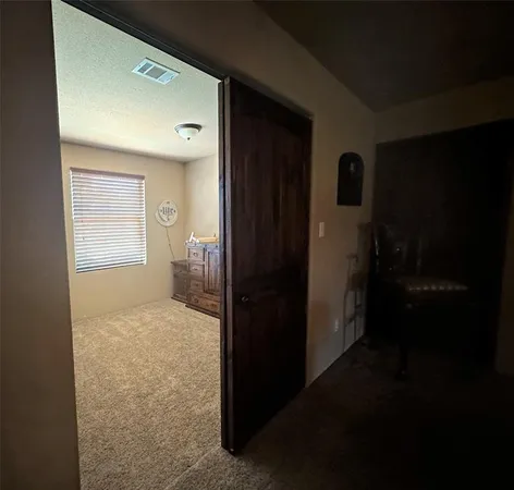 a view of hallway with bathroom and a window