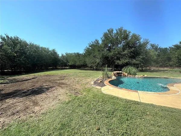 a view of a swimming pool and a yard