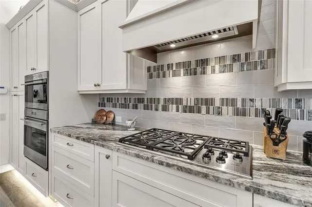 a kitchen with stainless steel appliances granite countertop a stove and a cabinets